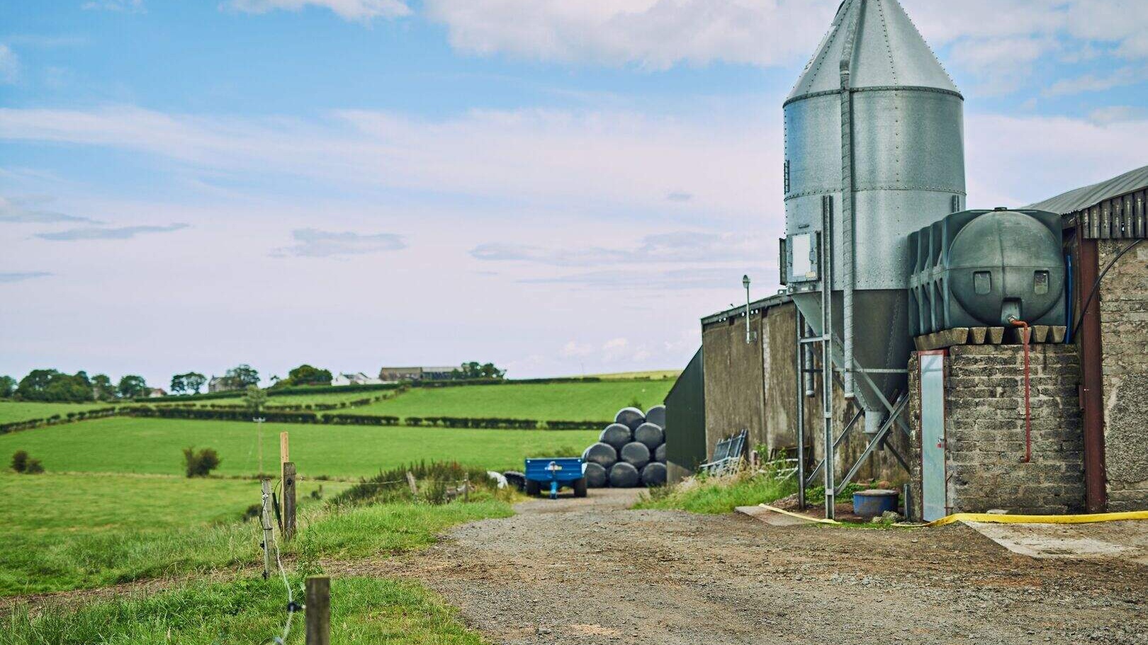 Metal grain silo being professionally coated and spray painted