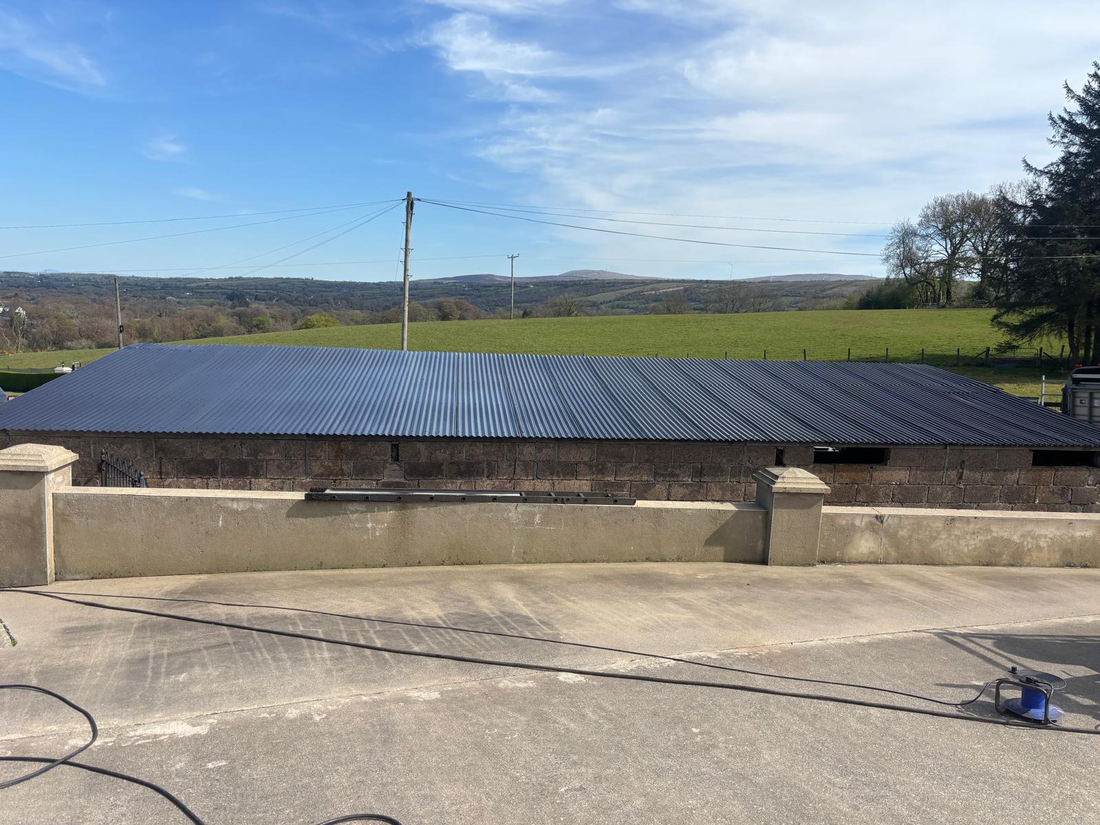 Freshly coated corrugated roof with green hills in the background