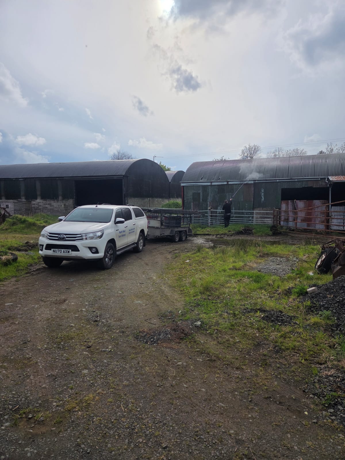 Northwest Farm Sprayers Hilux with worker spraying barn in background
